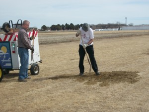 Perry Mitchell and Pat Greenwood fill a runway hole. 